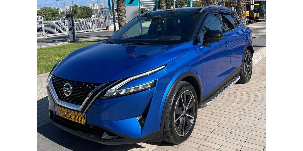 מבט מלפנים בזווית שמאלה על מכונית ניסאן קשקאי בצבע כחול מטאלי וגג שחור