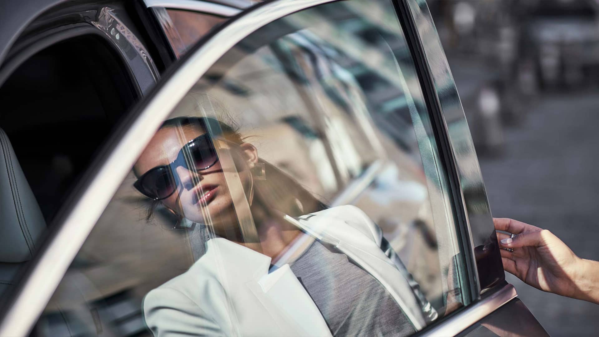 השתקפות של אשה בחלון של מכונית אינפיניטי QX50